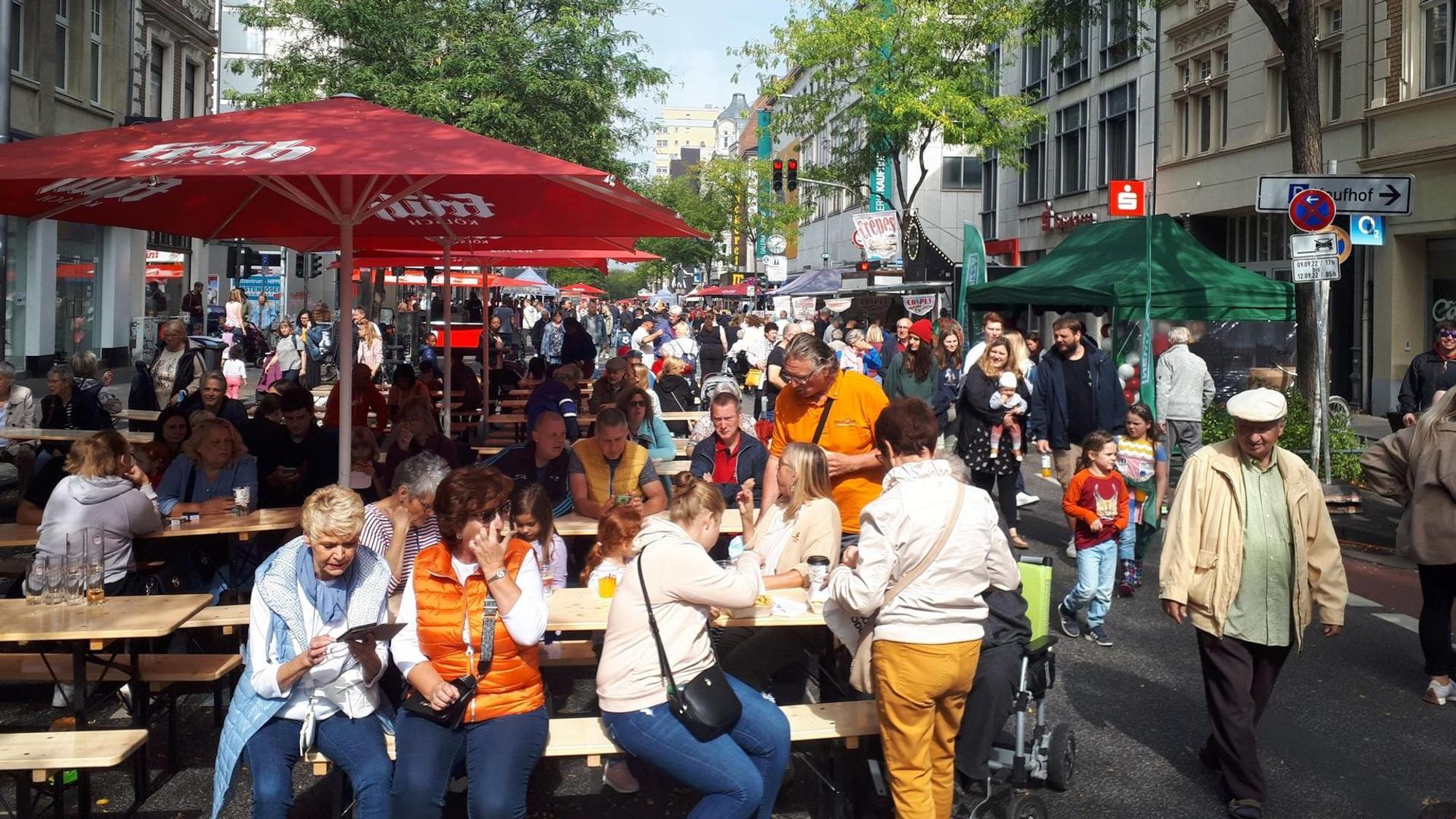 Viele Leute sitzen unter einem Schirm.