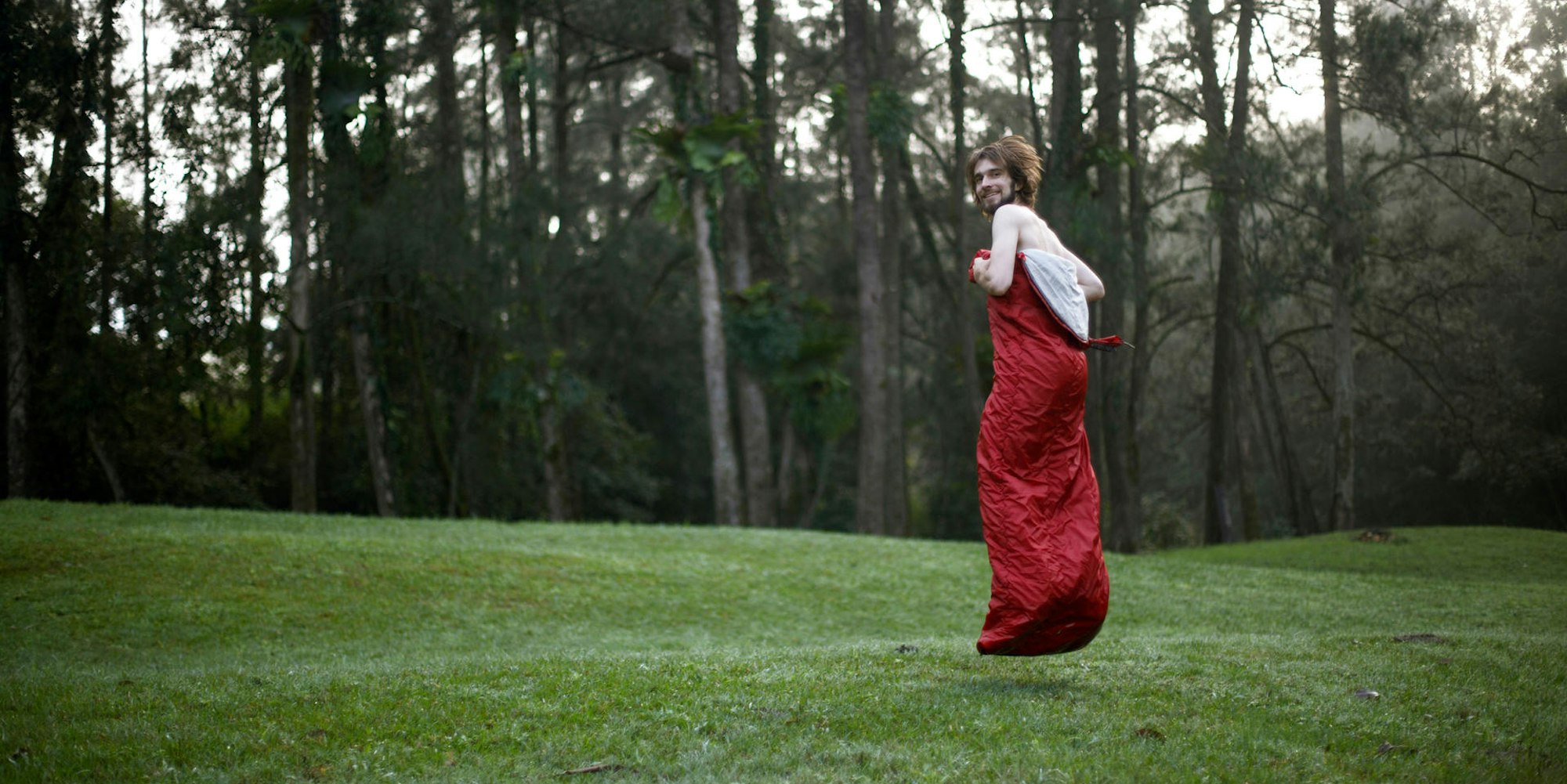 Mann huepft im Schlafsack Getty