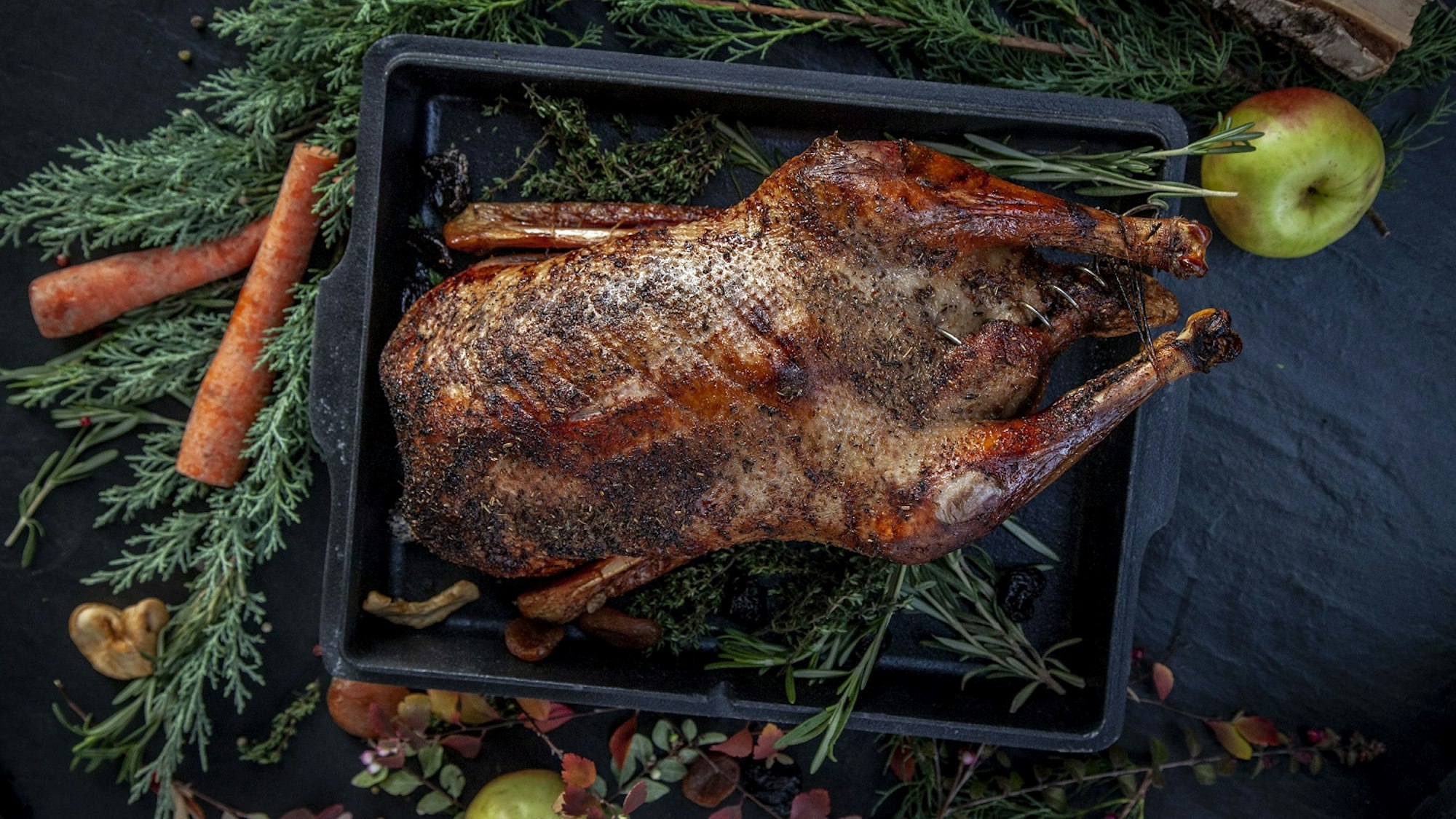 Angerichtete Weihnachtsgans mit Apfel und Möhren.