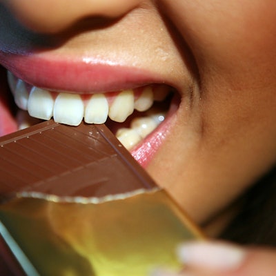 Frau beisst in Schokolade Süßigkeit