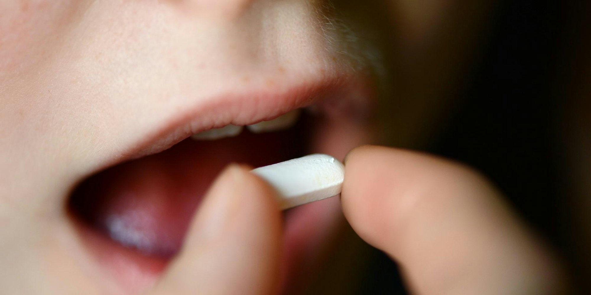 Kind nimmt weiße Tablette