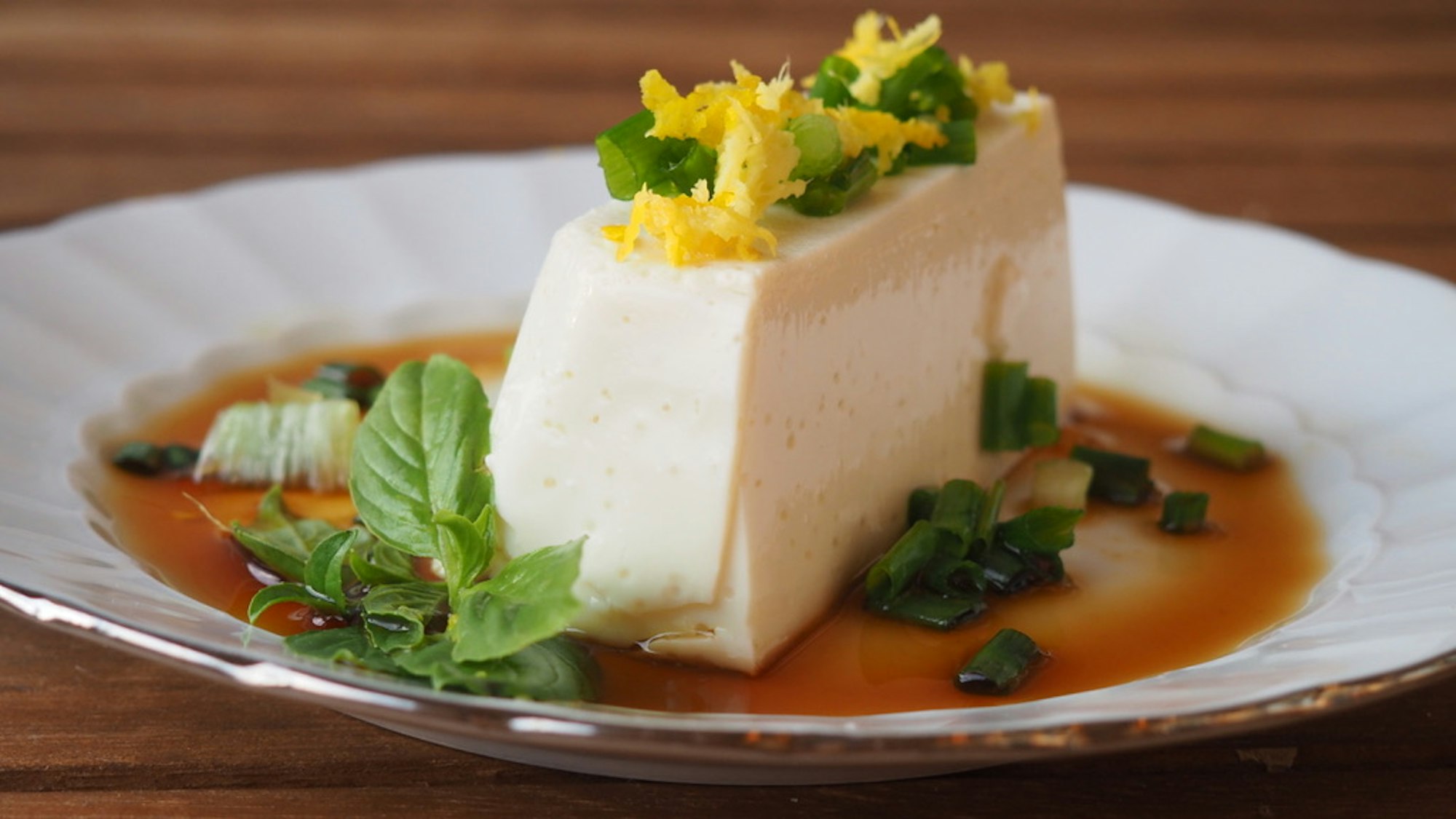 Seidentofu mit Zitronensauce auf einem Teller angerichtet.