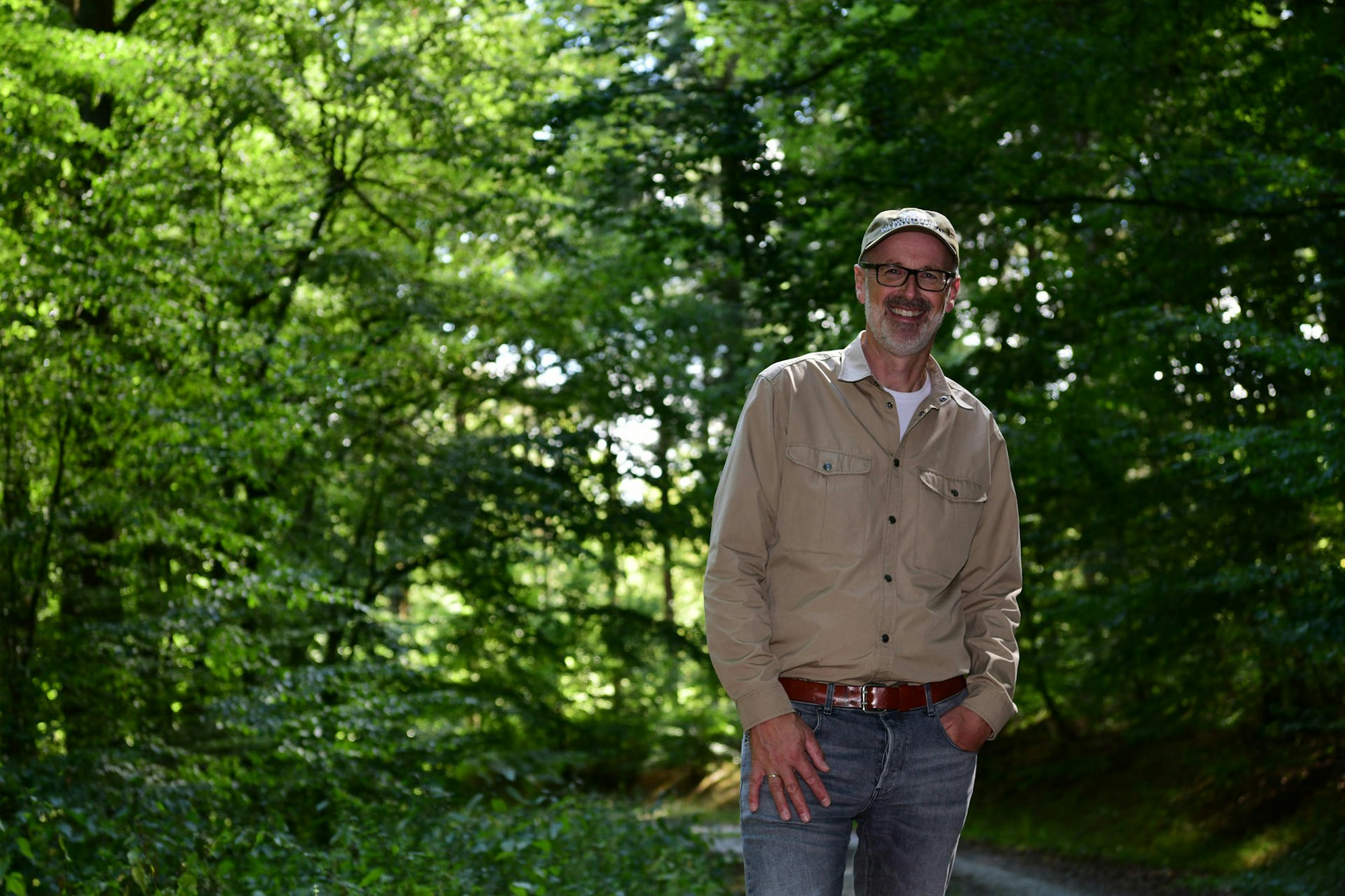 Peter Wohlleben steht vor grünen Bäumen