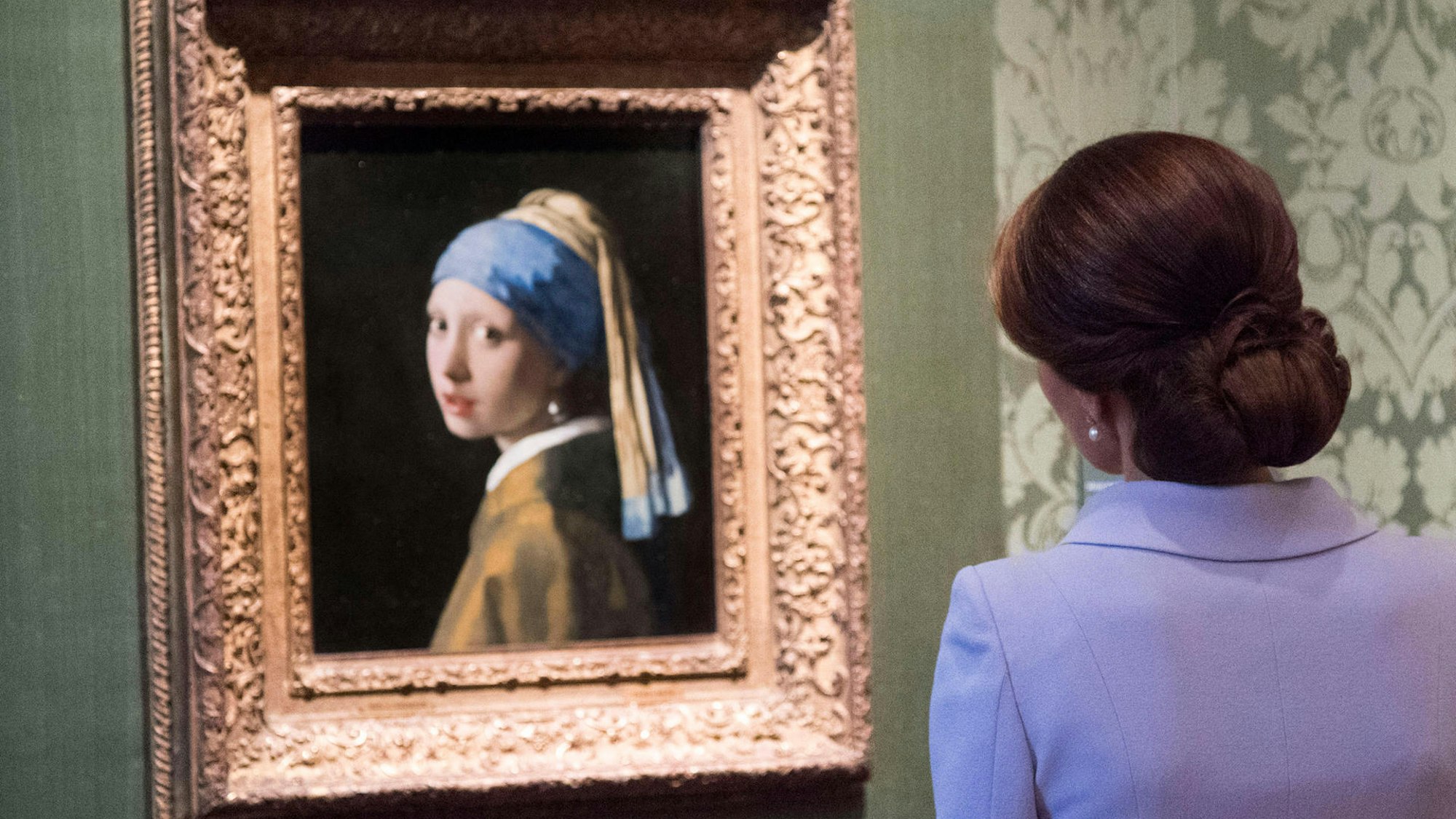 Frau schaut sich „Das Mädchen mit dem Perlenohrring“ an.