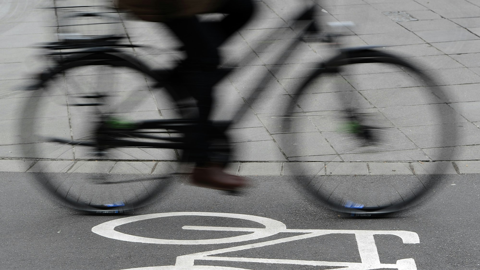 Das Foto zeigt einen Radfahrer auf einem Radweg, der mit einem Fahrradsymbol gekennzeichnet ist.