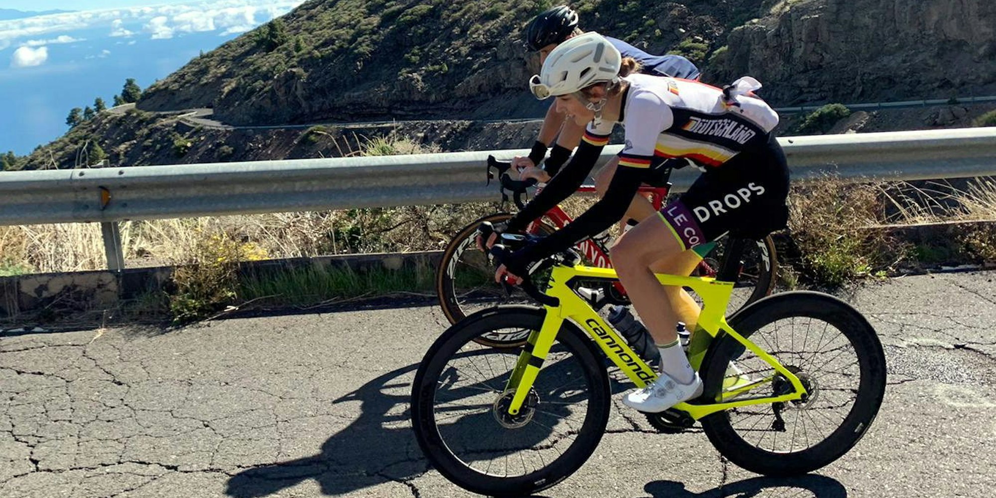 Finja Smelka ist mit einem weiteren Radfahrer auf einer Straße auf ihrem Fahrrad unterwegs.