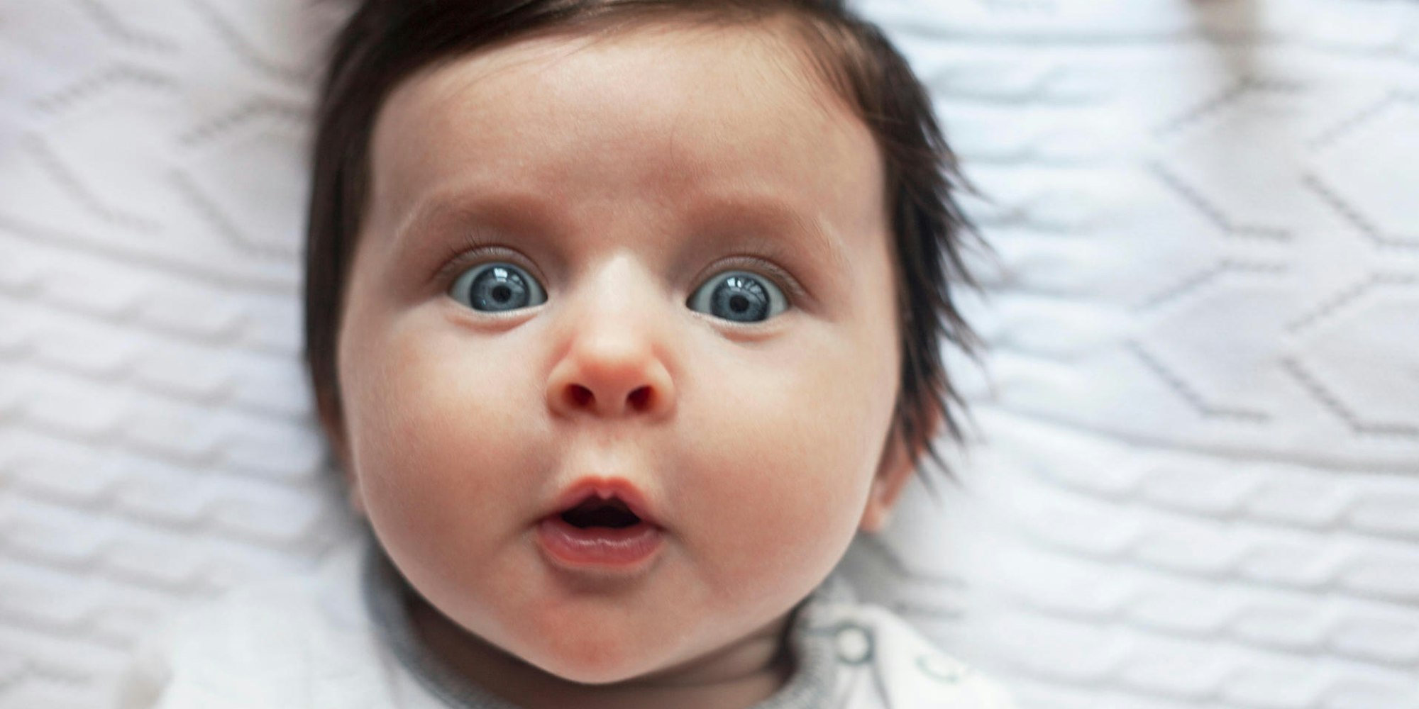 Ein Baby guckt staunend.