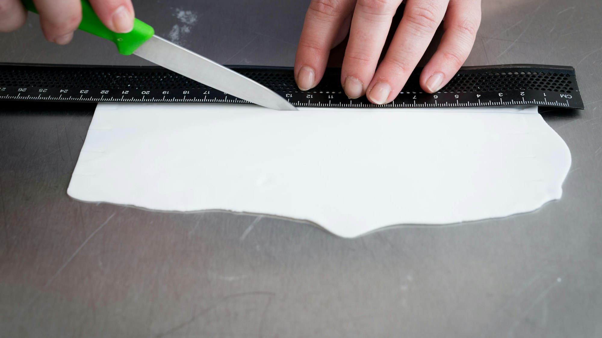 Weißer Fondant wird abgemessen.