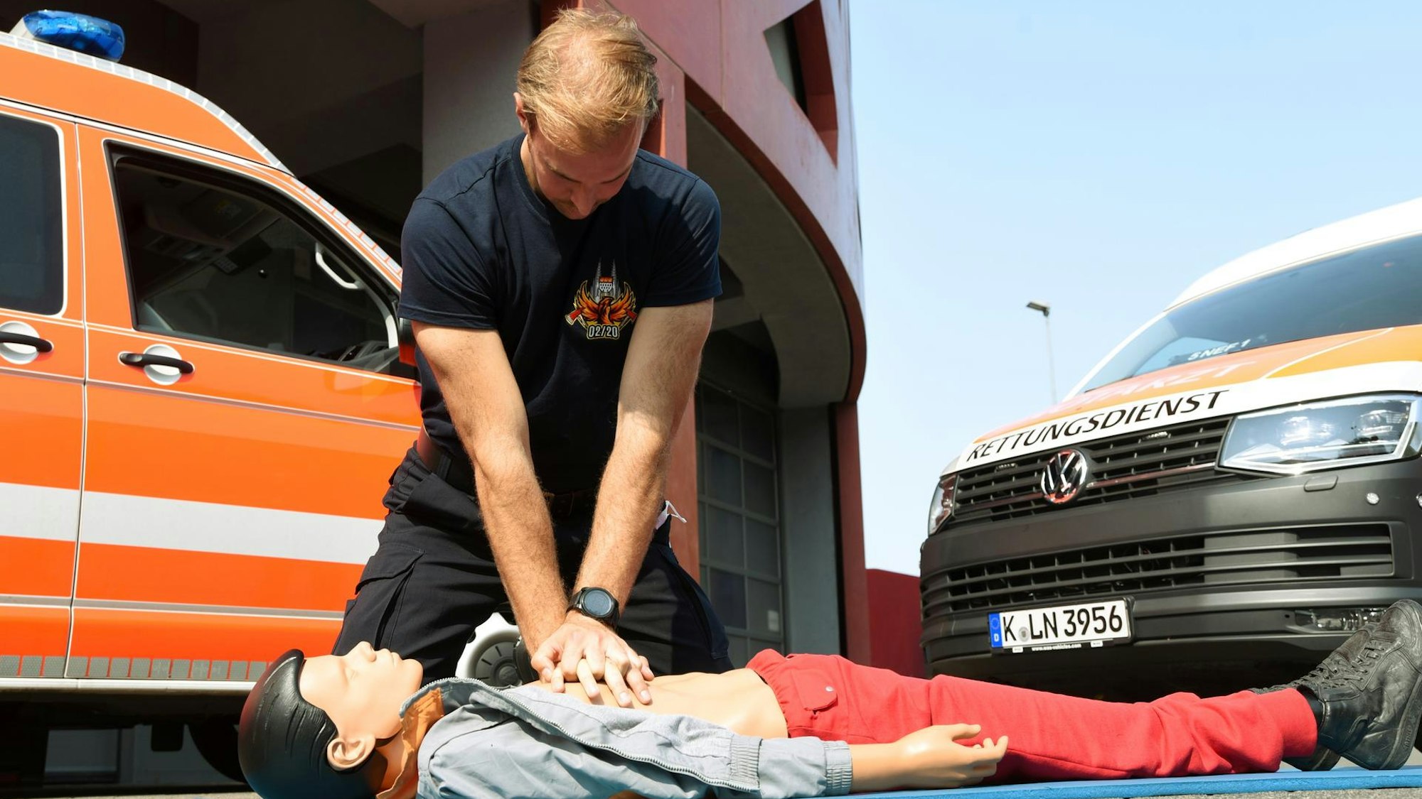 Ein Rettungssanitäter demonstriert an einer Puppe eine Herzdruckmassage.