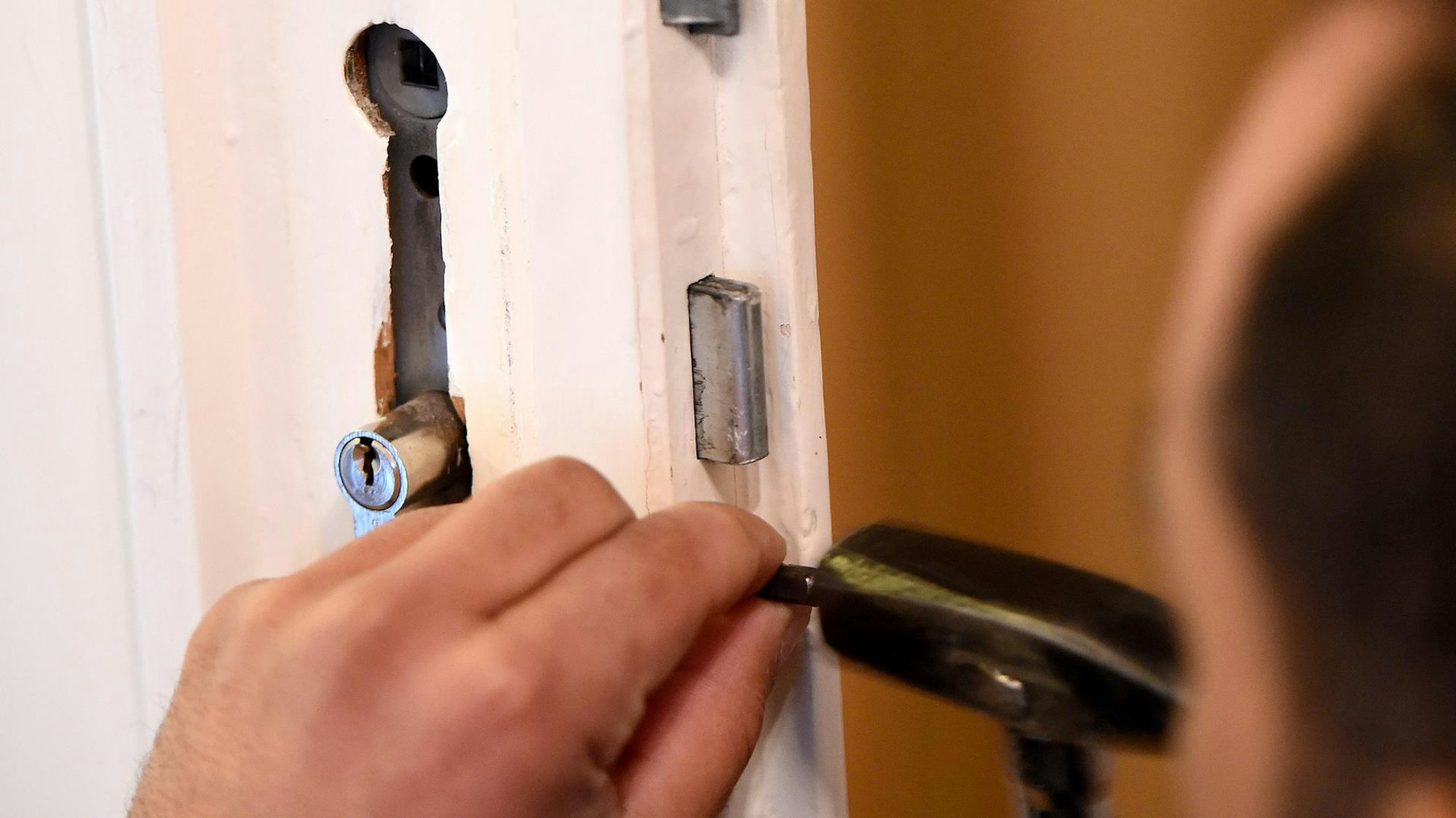 Der Mitarbeiter eines Schluesseldienstes bei der Arbeit.