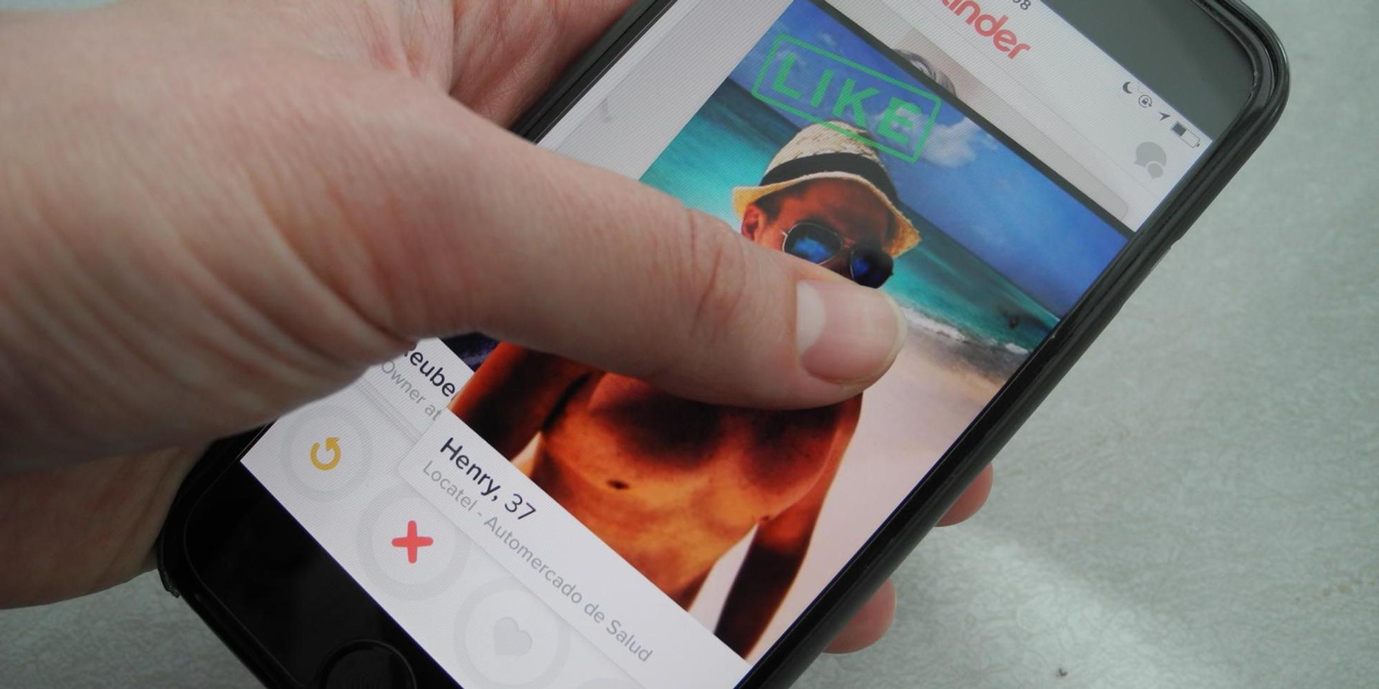 Eine_Frau_hält_ihr_Smartphone_in_der_Hand_auf_dem_Bildschirm_ist_die_App_Tinder