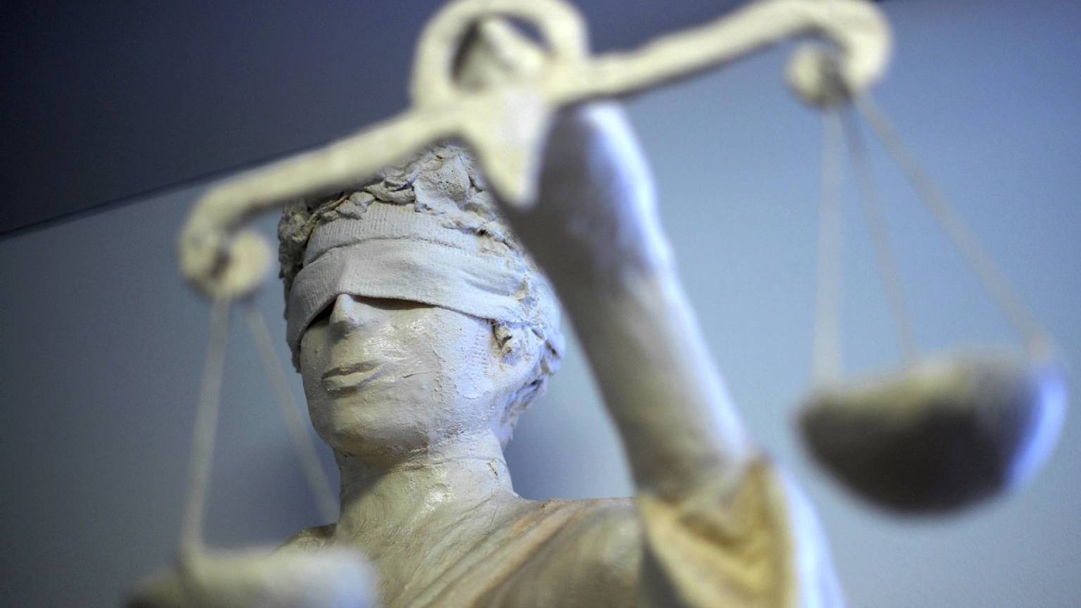 Eine Justitia-Statue hält mit verbundenen Augen eine Wage in der Hand.