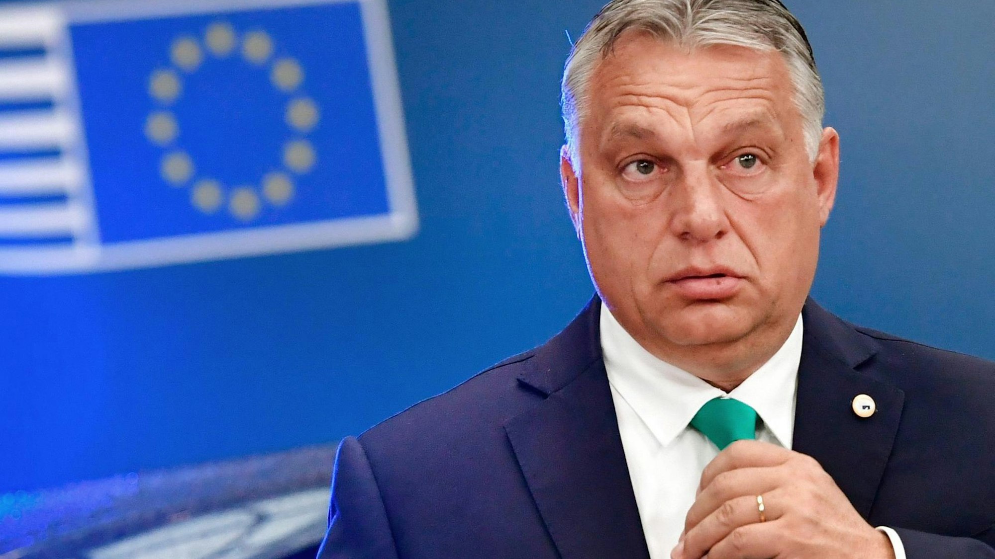 Ungarns Ministerpräsident Viktor Orban schreiben fasst sich an die Krawatte.