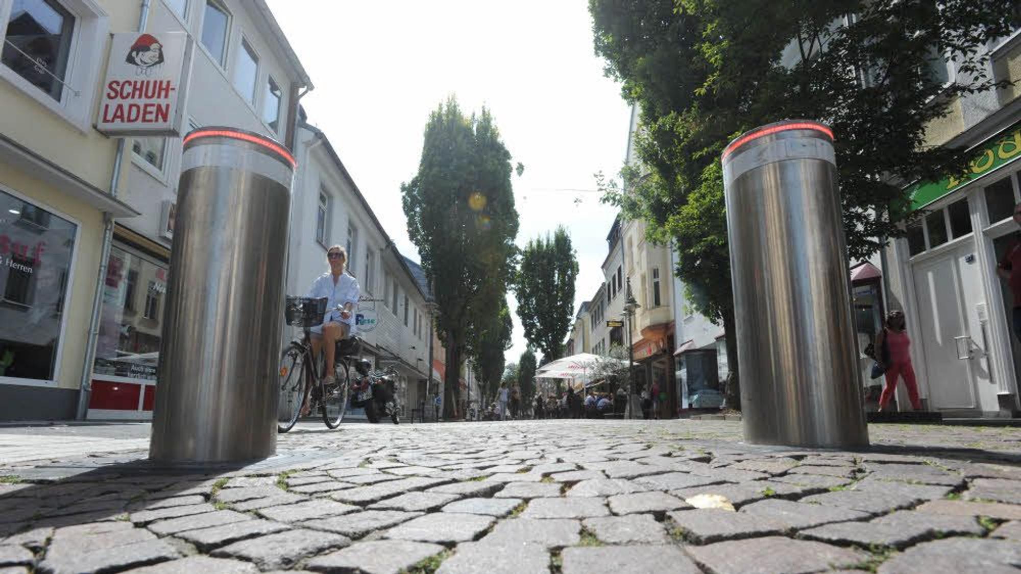 Das Foto zeigt eine Straße mit zwei versenkbaren Pollern im Vordergrund.