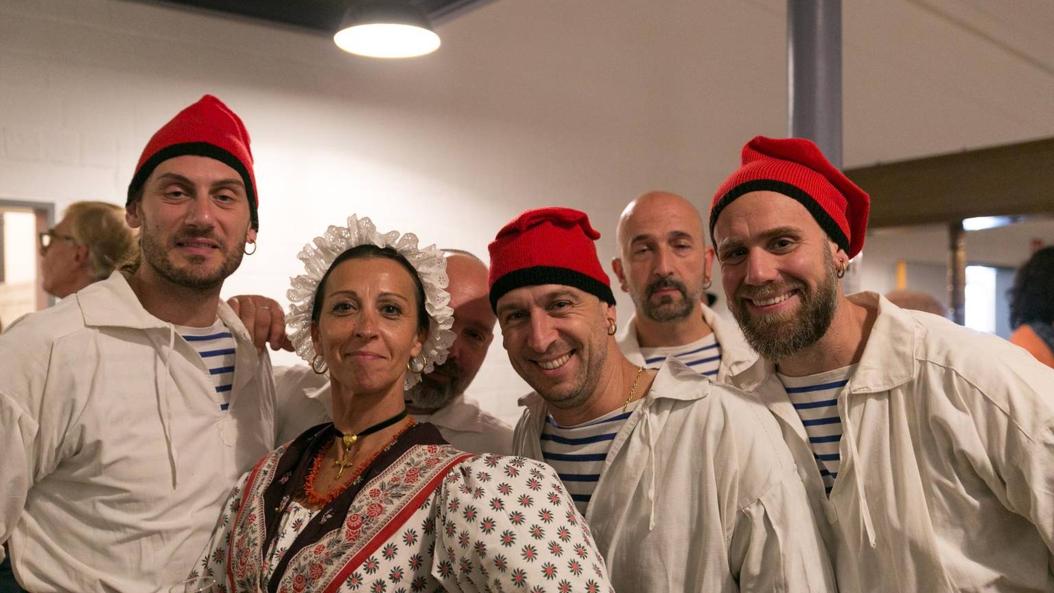 Die Folkloregruppe Le Grihet aus Plan-de-Cuques trägt traditionelle Kleidung: Rote Kopfbedeckungen und weiße Hemden.