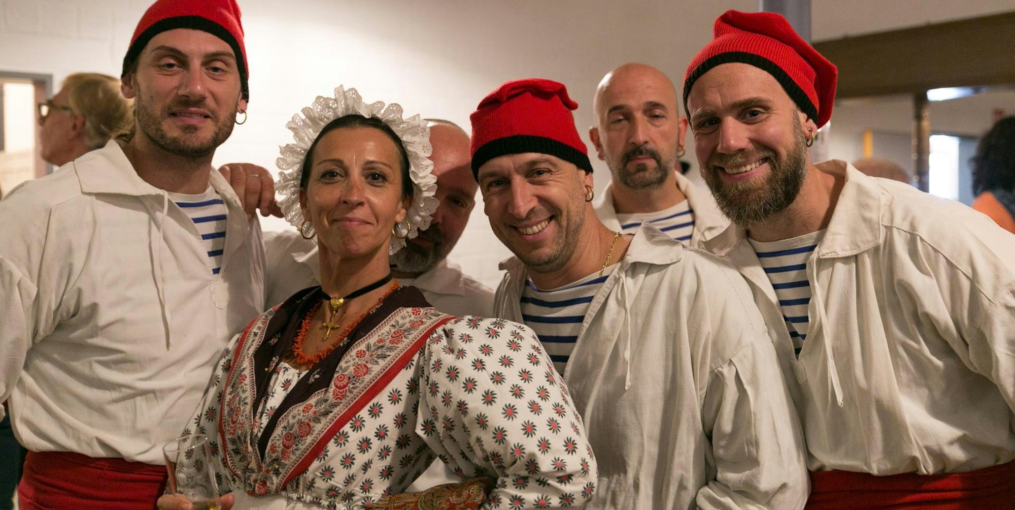 Die Folkloregruppe Le Grihet aus Plan-de-Cuques trägt traditionelle Kleidung: Rote Kopfbedeckungen und weiße Hemden.