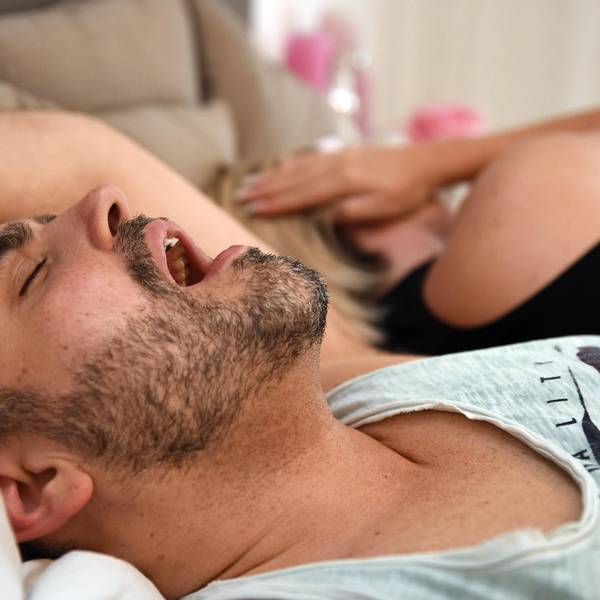 Mann schnarcht, Frau hält sich die Ohren zu
