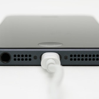 Ein iPhone hängt am Ladegerät