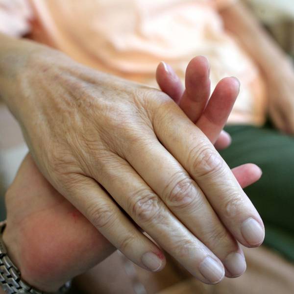 Ein_junger_Mensch_hält_eine_älteren_an_der_Hand_Palliativmedizin_Symbolbild_