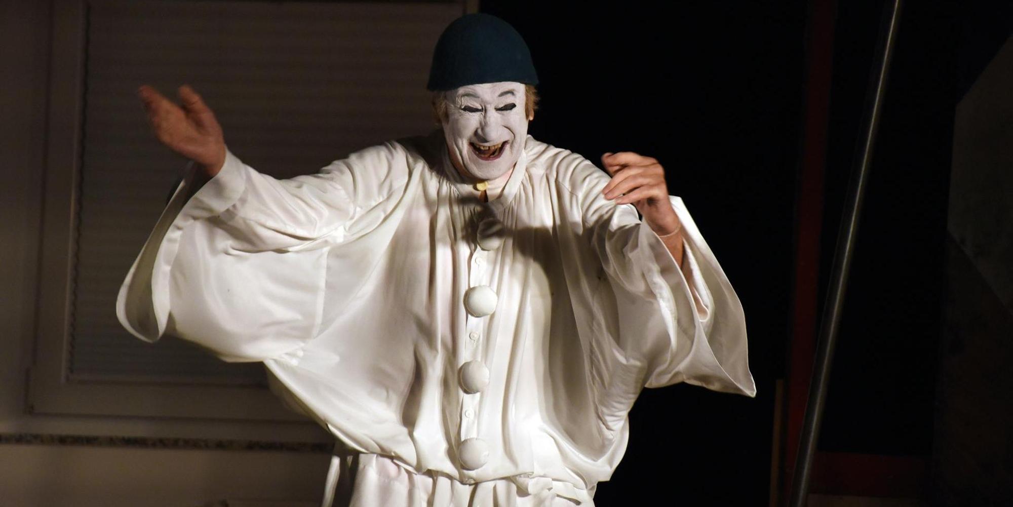 Milan Sládek steht in weißer Pantomime-Kleidung und weiß bemalten Gesicht lachend da.
