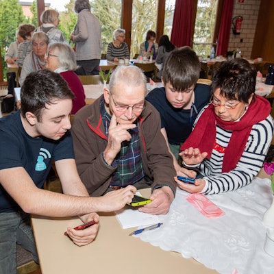 Schüler und Senioren am Handy