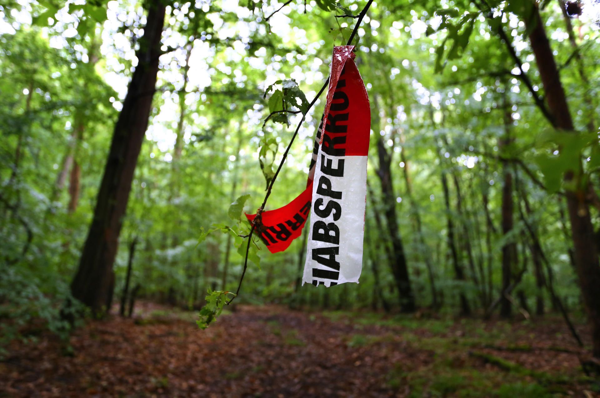 abgerissene Polizeiabsperrband im Wald am tag