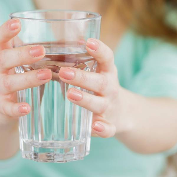 Frau hält Glas Wasser Symbol
