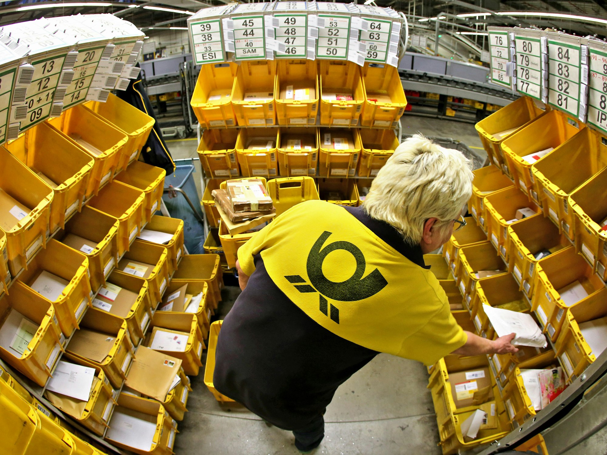 DHL-Mitarbeiterin sortiert Briefe.