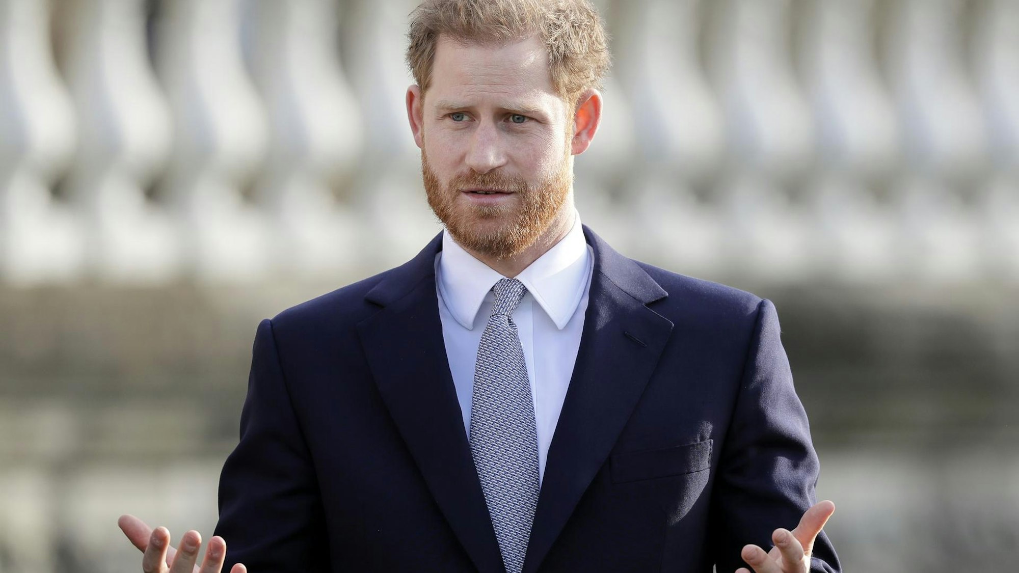 Prinz Harry hebt die Arme und Hände.