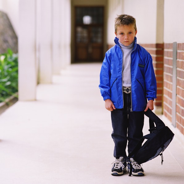 Ein Junge steht ängstlich im Schulflur.