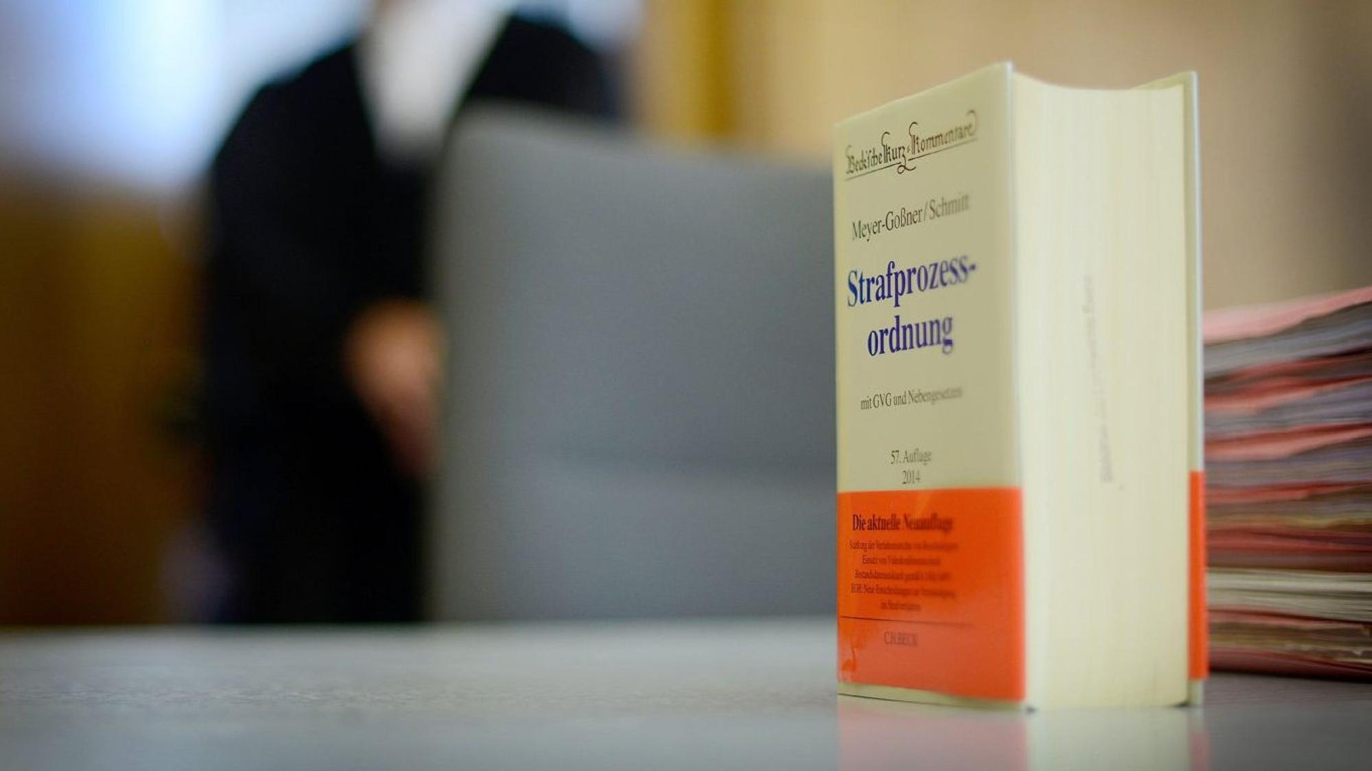Das Buch der Strafprozessordnung auf einem Tisch im Gerichtssaal.