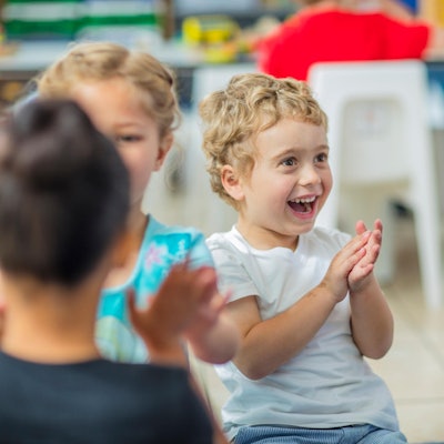Kinder klatschen in einer Kita.