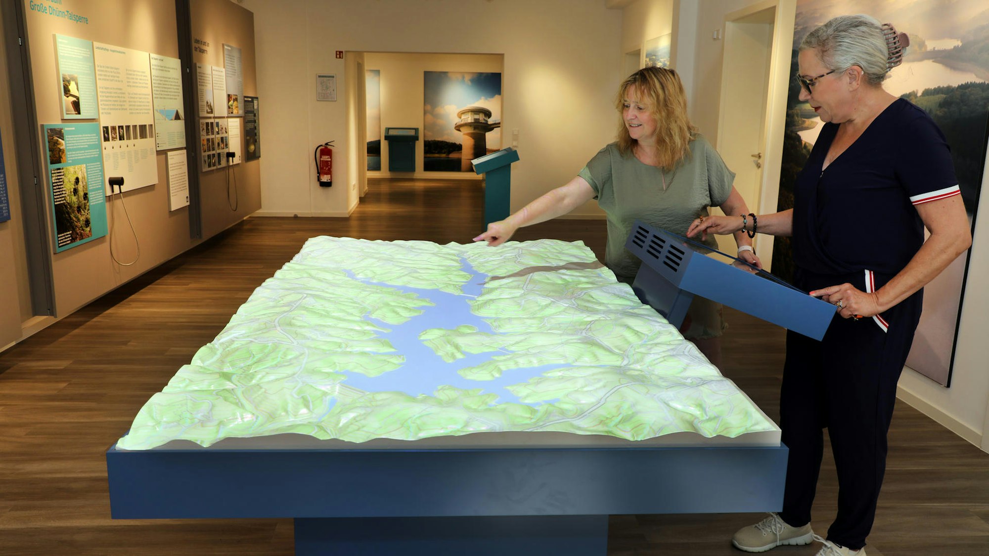 Zwei Frauen stehen an einem interaktiven Modell in der Wasserausstellung des Vereins Aqualon an der Großen Dhünn-Talsperre.