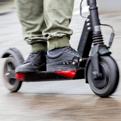 Ein Mann unterwegs auf einem E-Scooterr