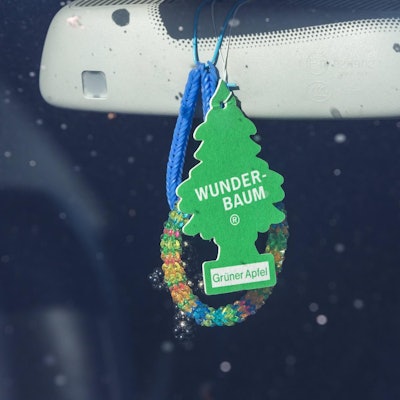 Duftbaum hängt an einem Autorückspiegel