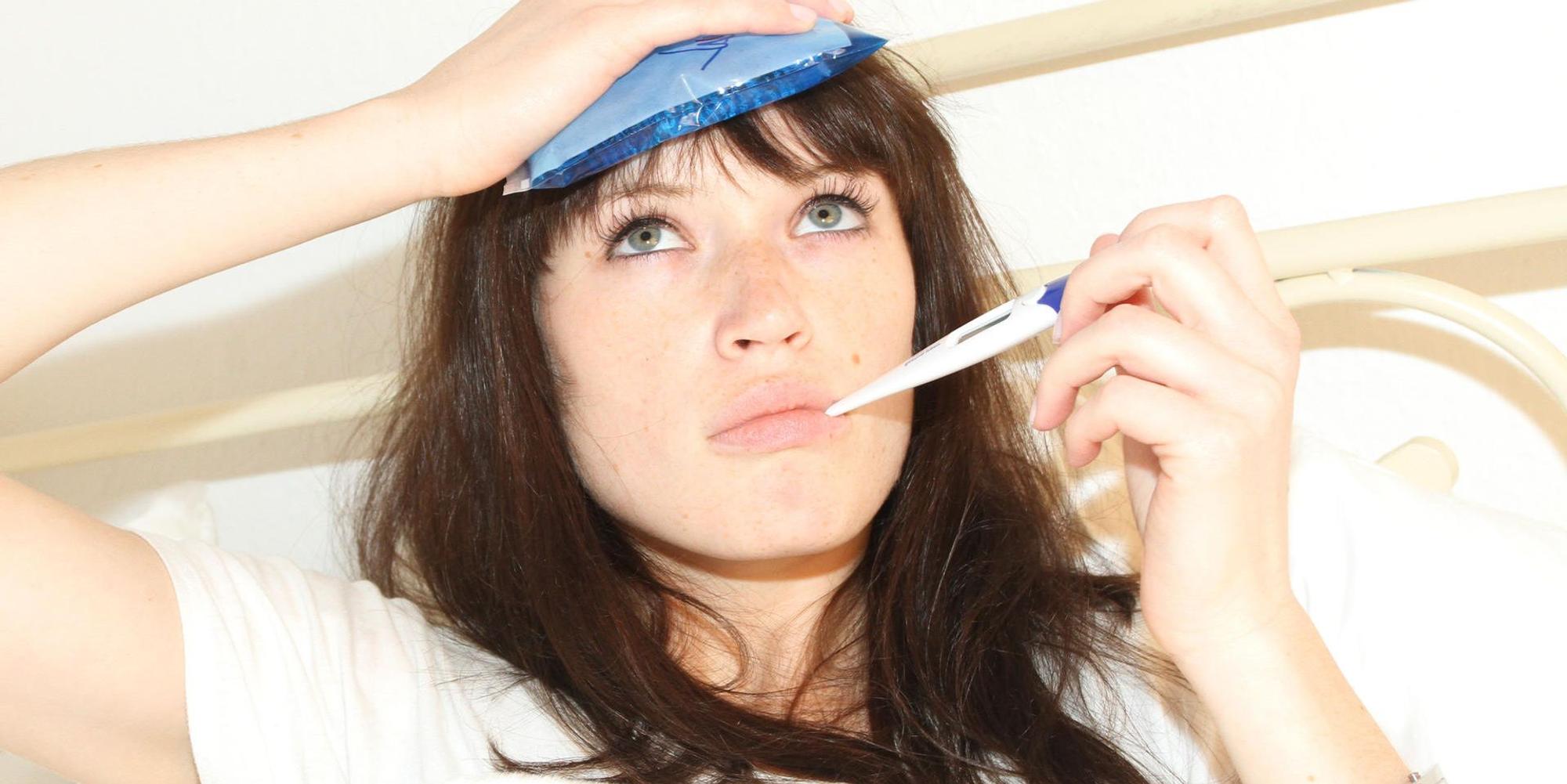 Frau liegt krank im Bett
