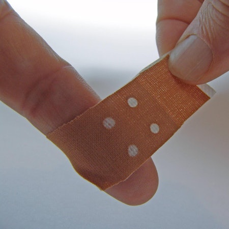 Pflaster_wird_um_Finger_nach_Papierschnitt_gewickelt