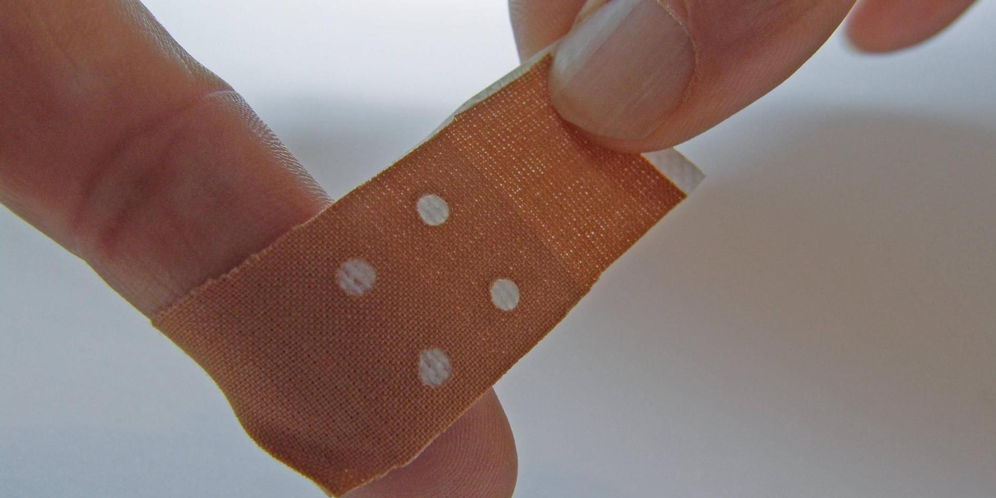 Pflaster_wird_um_Finger_nach_Papierschnitt_gewickelt