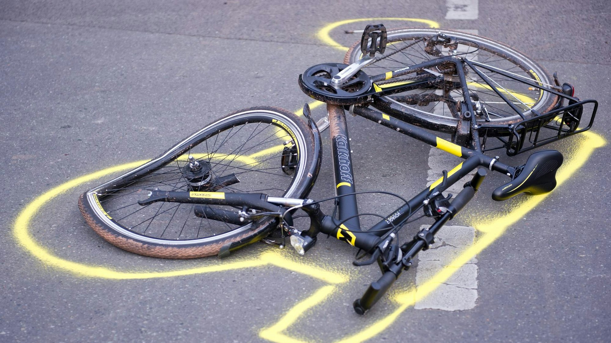 Ein Fahrrad liegt nach einem Unfall auf der Straße, seine Umrisse sind markiert.