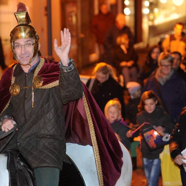 Ein als Sankt Martin verkleideter Mann hebt zum Gruß seine Hand.