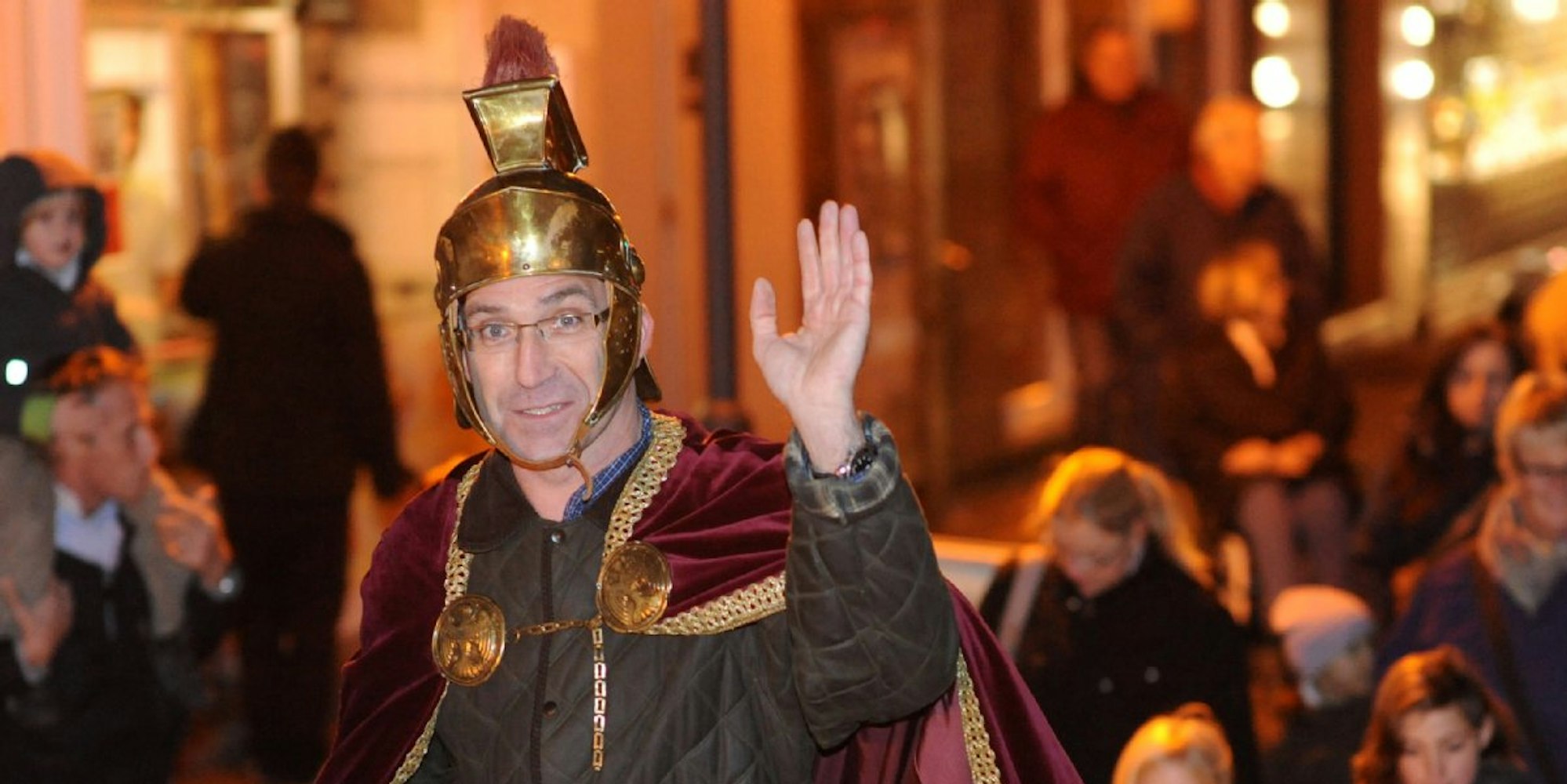 Ein als Sankt Martin verkleideter Mann hebt zum Gruß seine Hand.