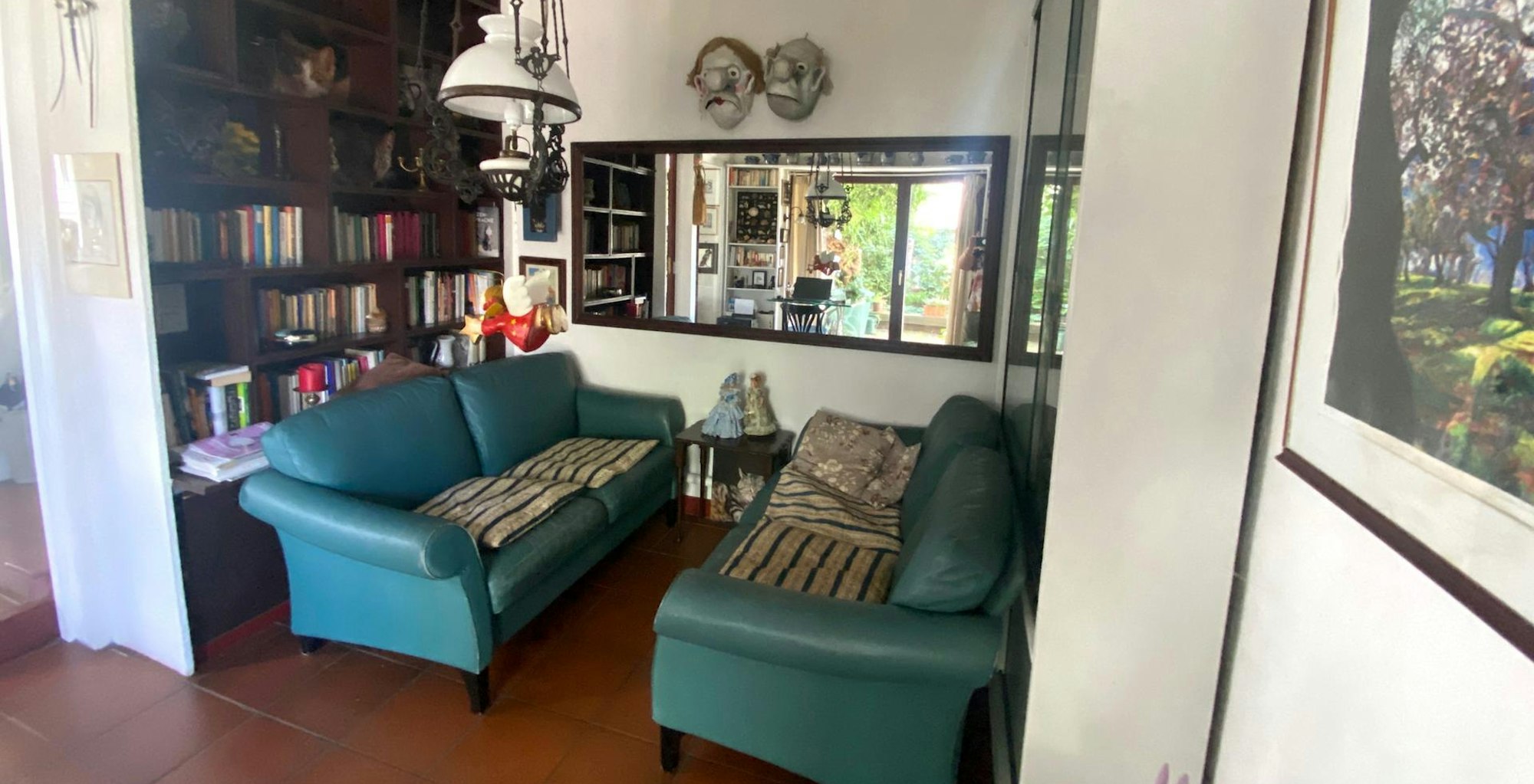 Im Wohnzimmer sitzt man sich auf zwei grünen Sofas wie in einem Zugabteil gegenüber.