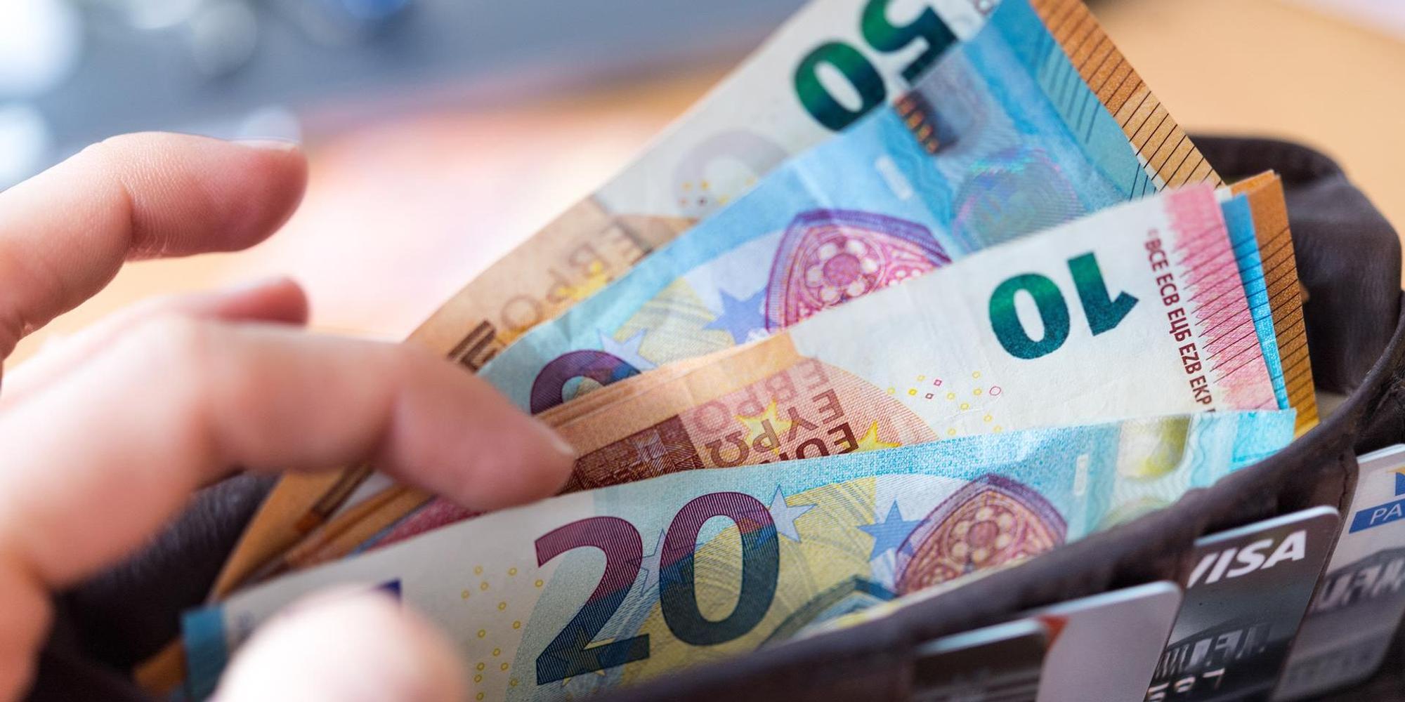 Hand zählt Geldscheine in Portemonnaie