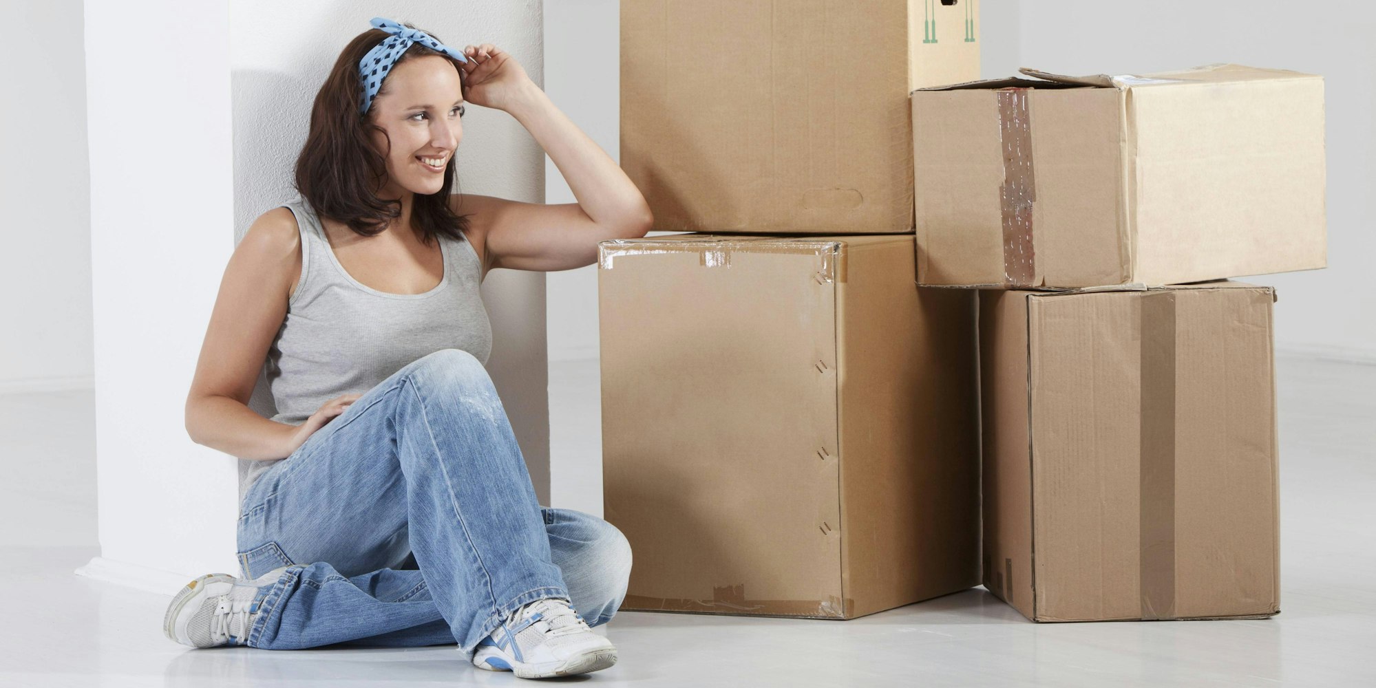 Frau neben Kartonstapel