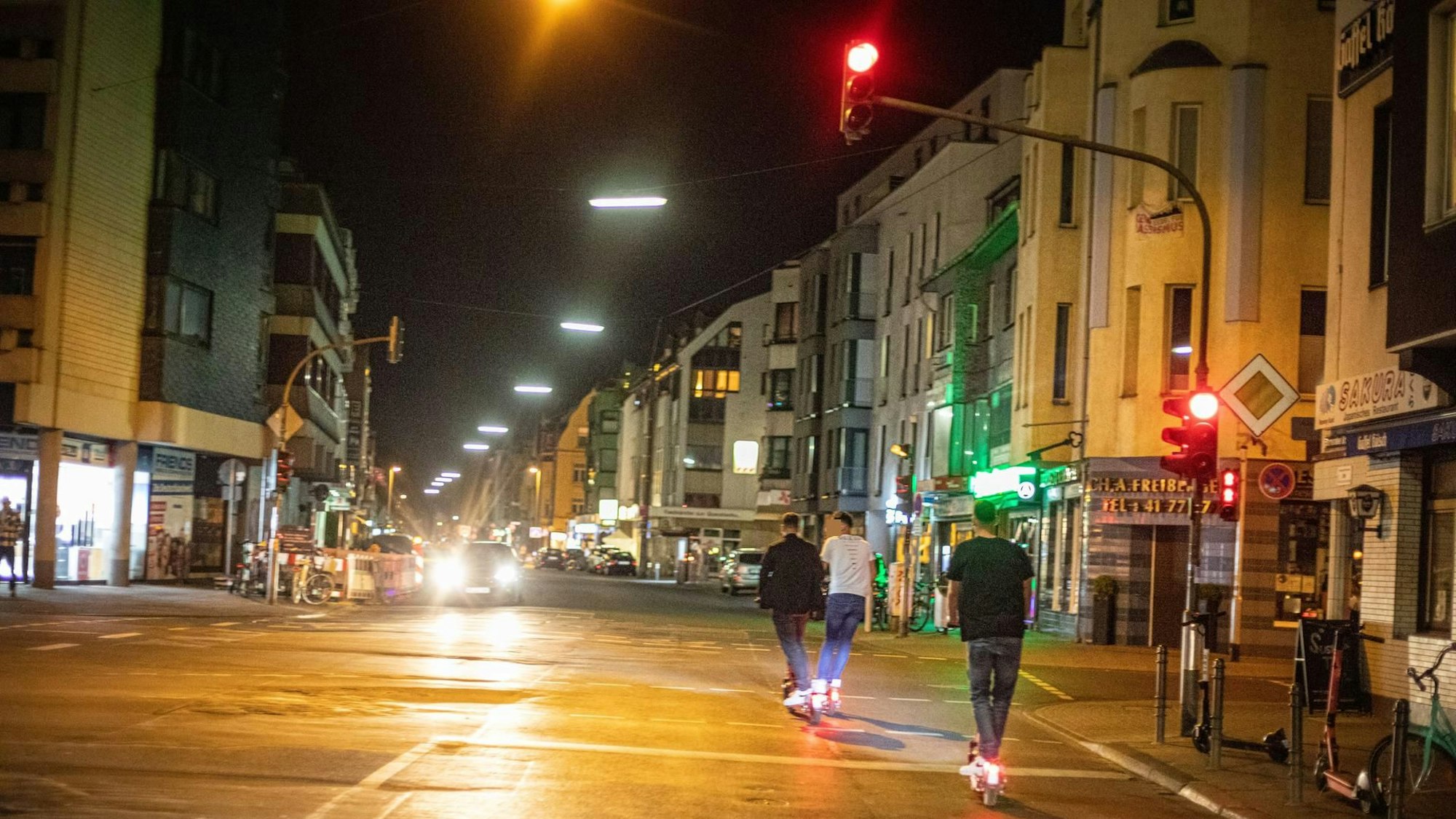 Drei Männer fahren auf E-Scootern.