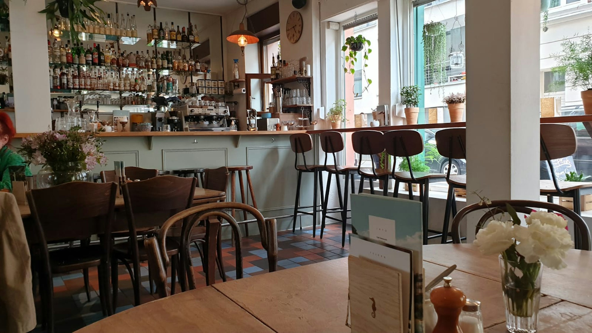 Das Café Sehnsucht in Ehrenfeld mit einer einladenenden Einrichtung und Blumen auf den Tischen