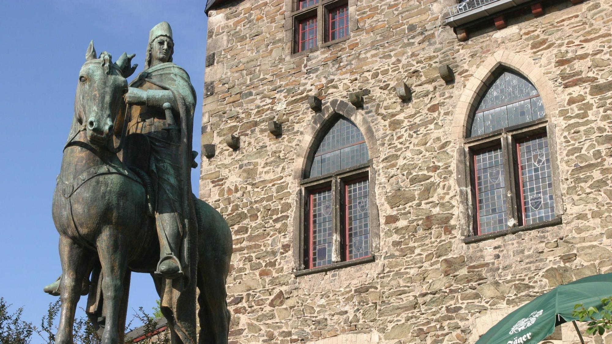 Eine Statur von Engelbert von Berg sitzt auf dem Pferd vor Schloss Burg.
