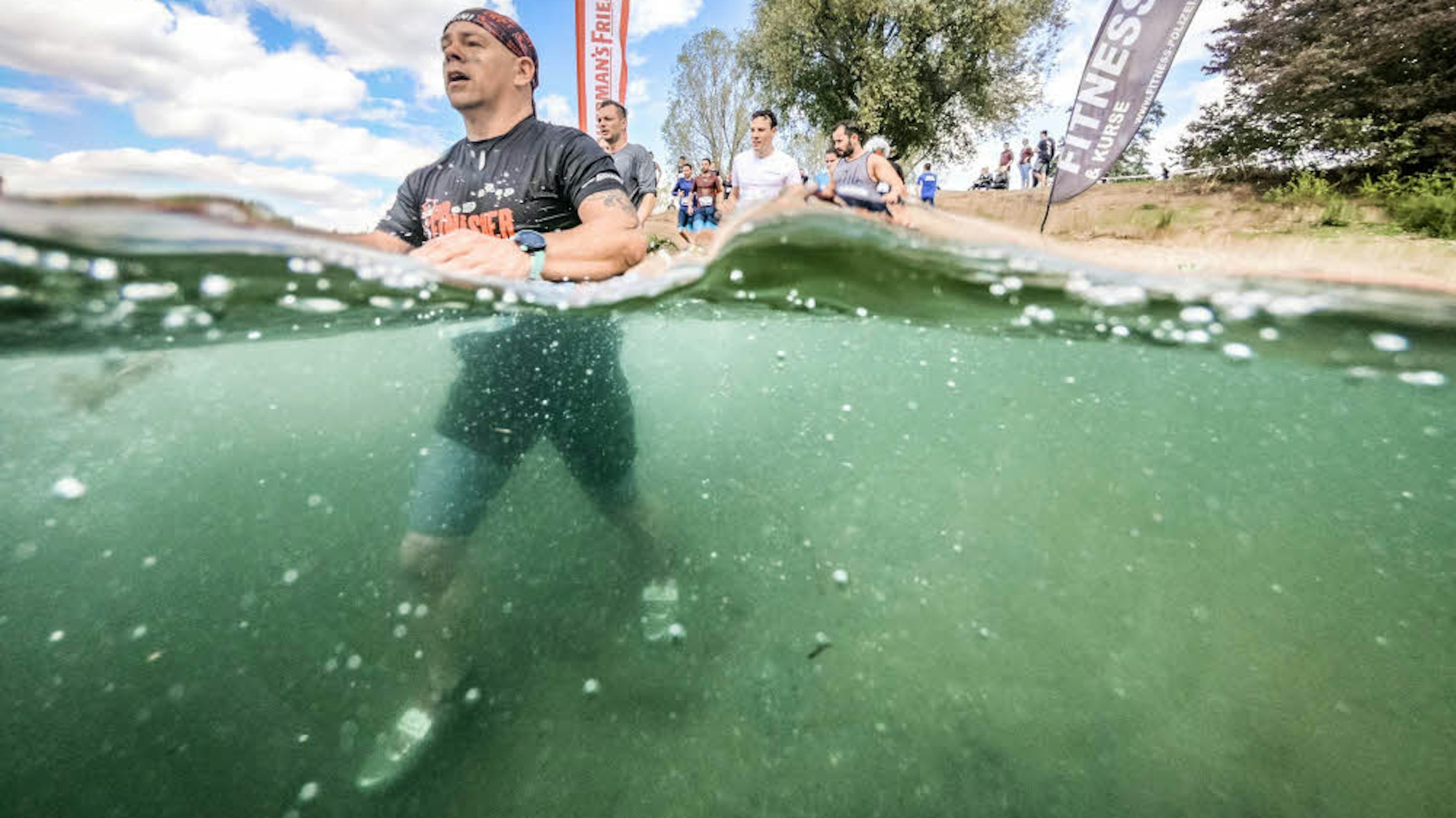 Ein Läufer durchquert eine tiefe Wassergrube.