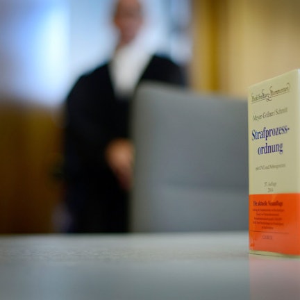 Das Buch der Strafprozessordnung auf einem Richtertisch.