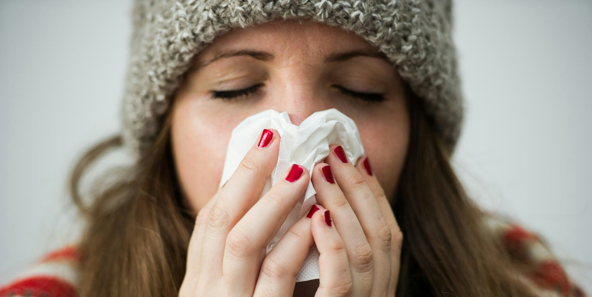 Frau putzt sich die Nase